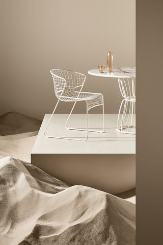 ND chair and table set against a neutral wall with sandstone textures.