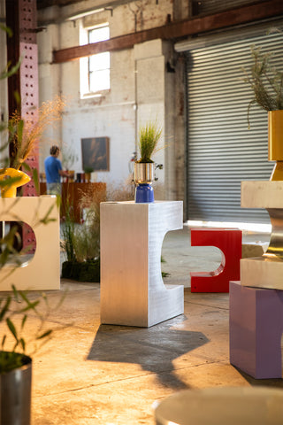 Blue/Nickel planter in modern interior design with abstract furniture pieces and plants.