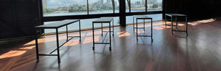 tables on a wooden floor with a waterfront view.