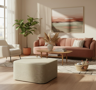 Modern living room with pink sofa, ottoman, and decorative elements.