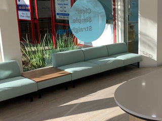 Modern office interior with a reception desk, chairs, and glass walls.