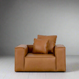 Brown leather armchair with two cushions against grey background