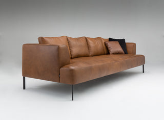 Brown leather sofa with black legs on a gray background