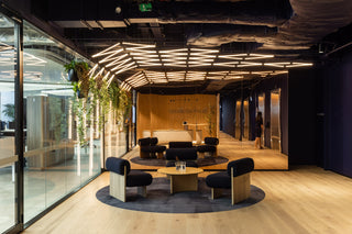 Modern office interior with round seating area and glass walls.