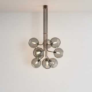 Modern chandelier with multiple glass shades on a white wall