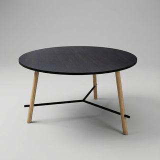 Round black table with wooden legs on a gray background