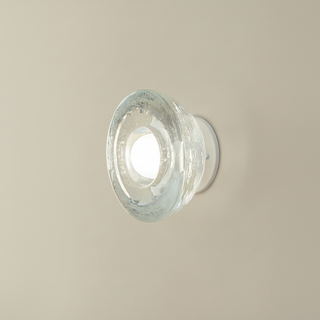 Cast glass sconce white satin fitting on a beige wall