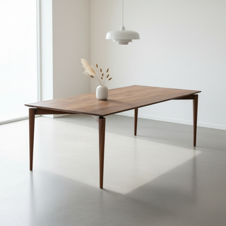 Wooden dining table with a vase of dried plants in a minimalistic room.
