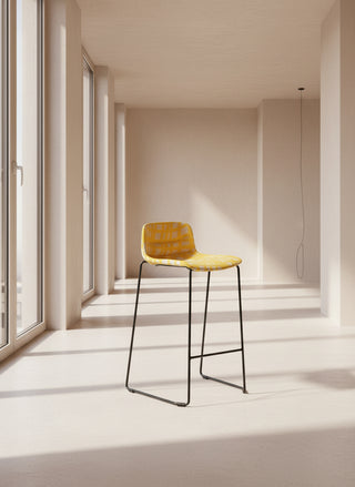 Yellow bar stool with black legs on a white background