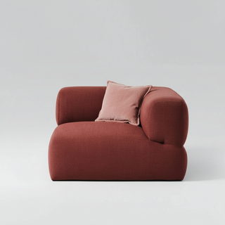 Red armchair with a pink pillow on a light gray background