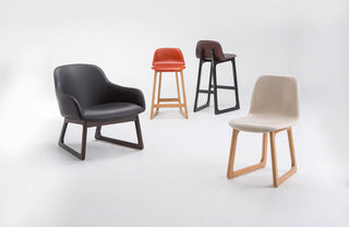 Set of modern chairs including a black armchair, two bar stools with different finishes, and a beige chair on a white background.