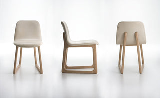 Three modern chairs with beige seats and wooden frames on a white background