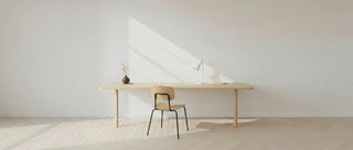 Minimalist desk setup with a chair in a bright room