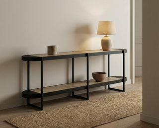 Console table with a lamp and decorative items in a minimalistic room.