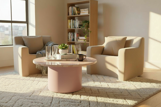 Modern living room with beige sofa, pink coffee table, and bookshelf.