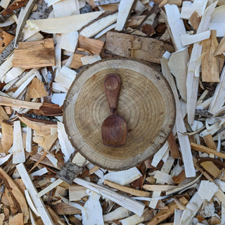 Dimple-shaped wooden spoon on wood slice
