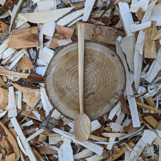 Large wooden yogurt spoon on wood slice