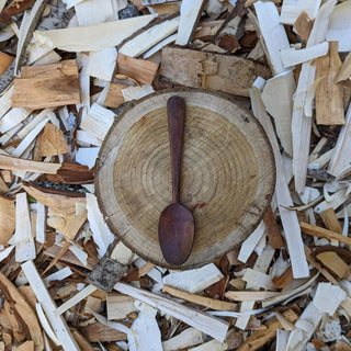Wooden yogurt spoon on wood slice